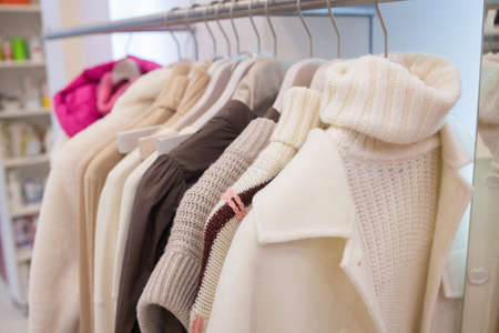 Pastel knit warm sweaters on white hangers.の写真素材