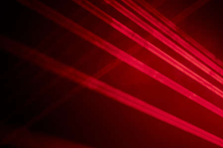 Bright red neon laser lights illuminate the darkness creating lines and triangle shapes in sci-fi effect.の写真素材