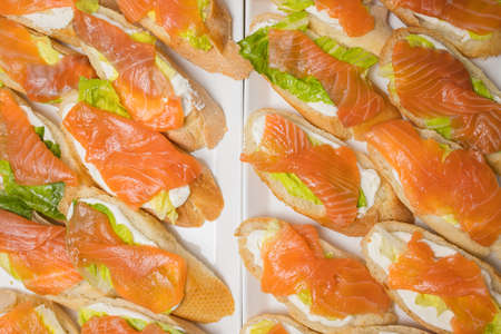 Canapes of fish, bread, cheese and herbs on skewers.の写真素材