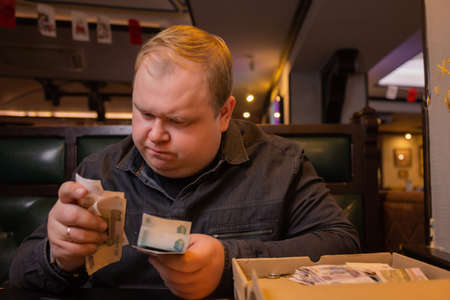 Elderly man counts russian rubles in hands. Pension payments, retirement savings or benefits...