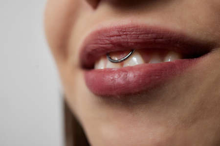 smile or frenulum piercing under the upper lip.