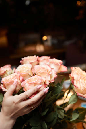 The bride holds a wedding bouquet of peach and white roses and flowers.の写真素材