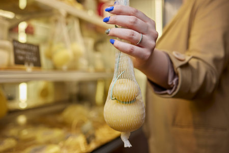 Delicious fresh Caciocavallo and Scamorza cheese hanging. Italian cheeses close up. The cheeses are handmade. The production of cheese.の写真素材