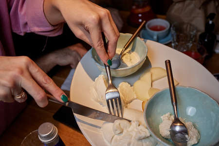 mozzarella cheese, basil. Close up. Top view. female hands cutting with a knife.
