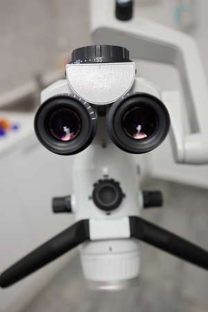 Dental microscope on the background of modern dentistry. Medical equipment. Dental operating microscope with rotary double binocular.の写真素材