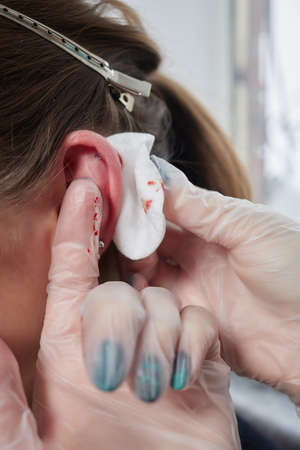 piercings on an ear. Conch and helix piercings close up.の写真素材