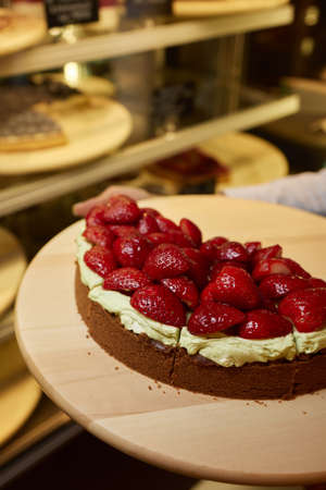 slice of delicious strawberry tart on green background, top view.