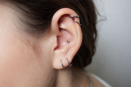 Stretched lobe piercing, grunge concept. Pierced woman ear with black plug tunnel. industrial and rook.の写真素材