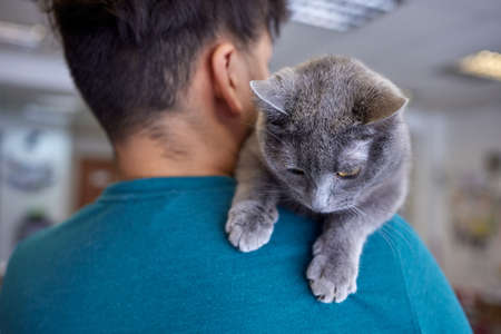 Young man in t shirt holding a cat.