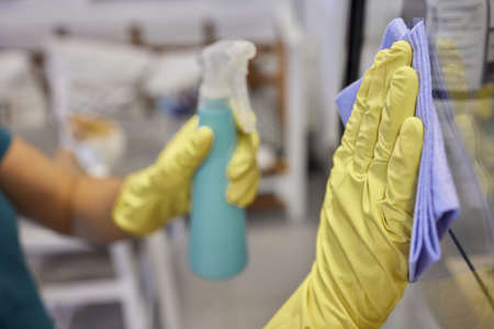 Man washing window in protective gloves closeup. Cleaning of apartments concept.