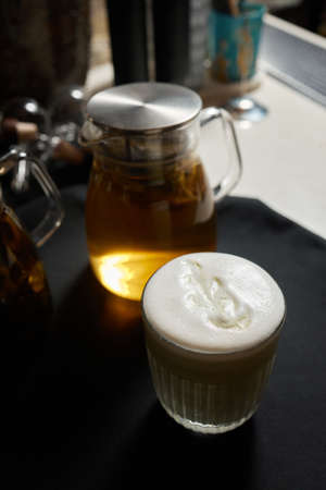 Coffee, a full cup of coffee with milk on the table flower pattern figure which made with crema.