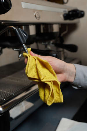 A perfectly lit cleaning cloth sat upon an espresso machine.