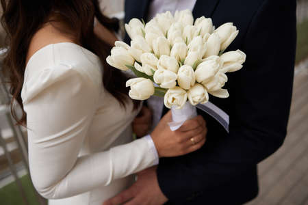 Beautiful large bouquet of white tulips in the hands of the bride.の写真素材
