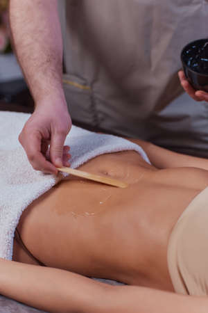 procedure removing cellulite on female abdomen, cavitation belly massage. Ultrasonic massage for weight loss. Correction of female figure without surgical intervention. Closeup of the tummy.の写真素材