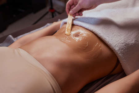procedure removing cellulite on female abdomen, cavitation belly massage. Ultrasonic massage for weight loss. Correction of female figure without surgical intervention. Closeup of the tummy.の写真素材