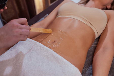 procedure removing cellulite on female abdomen, cavitation belly massage. Ultrasonic massage for weight loss. Correction of female figure without surgical intervention. Closeup of the tummy.の写真素材