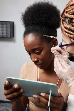 Close up of womans ear with pierced on her ear for treatment of the pain some place on her body by Chinese doctor.の写真素材