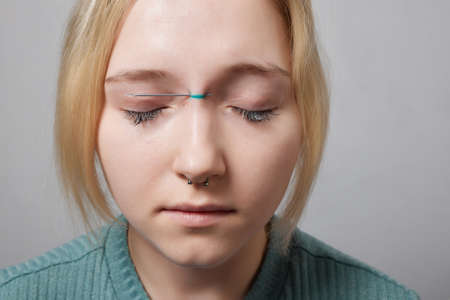 Nose Bridge Piercing Professional holding the jewel of piercing day just before screw the ball.