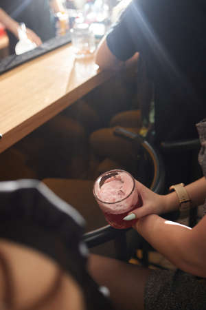 Low angle closeup of a gourmet mixed drink cocktail of sweet pink lemonade vodka and gin martini,...