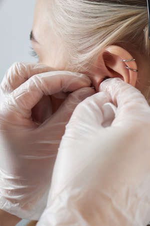 Professional holding the jewel of piercing day just before screw the ball. Tragus type.の写真素材