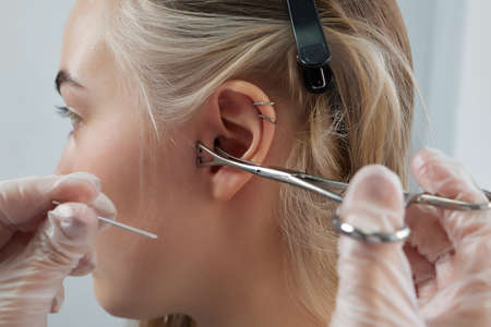 Professional holding the jewel of piercing day just before screw the ball. Tragus type.の写真素材