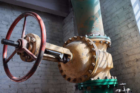 Close-up at pipeline valve which is using to control production process in the oil refinery plant....
