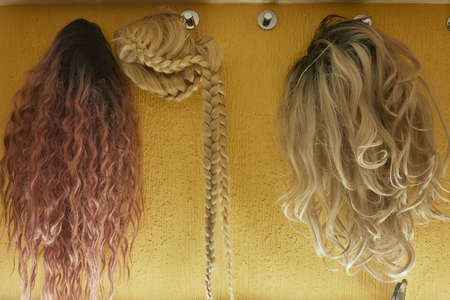 Wigs, natural and synthetic hair. Womens beauty concept. Close up photo of wig, hair for ladies.