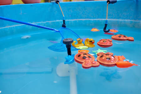 Multicolored plastic toy fish in pool for childrens fishing, concept game.