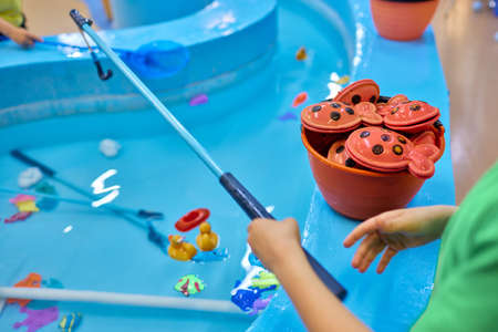 Multicolored plastic toy fish in pool for childrens fishing, concept game.