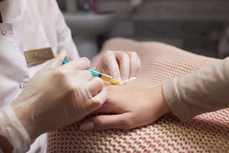 Doctor doing stem cell therapy on a patients elbow after the injury. Treating knee pain with platelet-rich plasma injection. Treatment of arthritis and osteoarthritis.Medical and cosmetology concept.の写真素材
