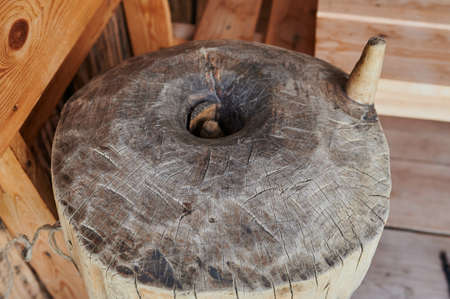 An ancient hand mill made of stones and wood. Flour grinding device. Authentic handicraft.