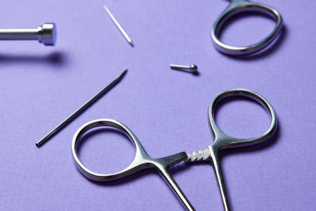 Piercing earrings close-up. On a Violet background.の写真素材