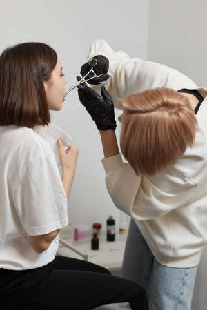 Tongue piercing operation Professional holding the jewel.の写真素材