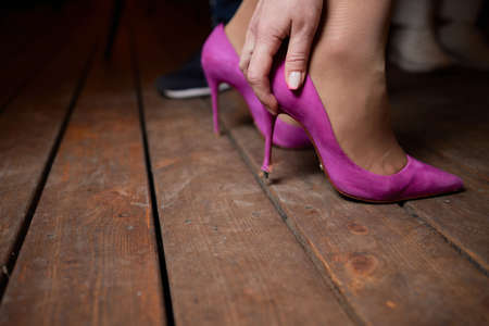 a womans foot in a shoe got stuck in the wood floor. hole.の写真素材