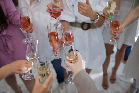 Celebrating with glasses of alcohol in hands. Happy female friends having good time.