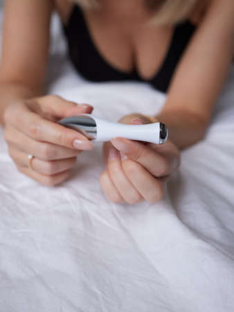 beautiful girl in sexy clothes holding in her hands a sex toy for adults.の写真素材