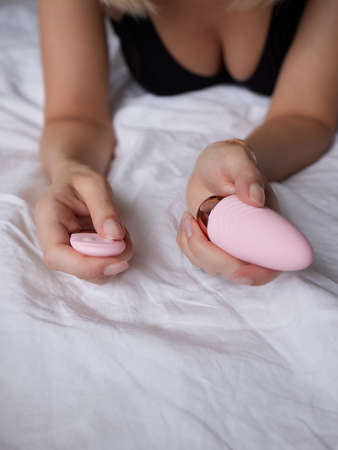 beautiful girl in sexy clothes holding in her hands a sex toy for adults.