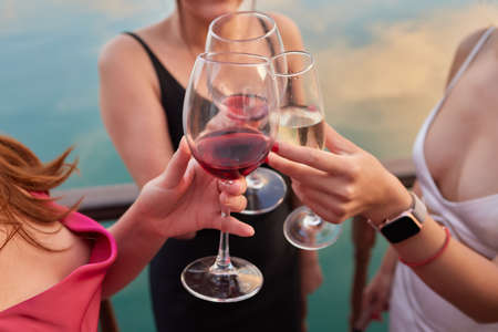 Celebrating with glasses of alcohol in hands. Happy female friends having good time.の写真素材