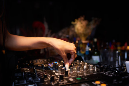 Hands of female Dj playing music on modern midi controller turntable. Digital device for mixing...
