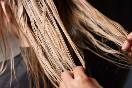 Airtouch Hair stylist makes bouffant using comb on thin strands. Shatush technique for hair lightening.の写真素材