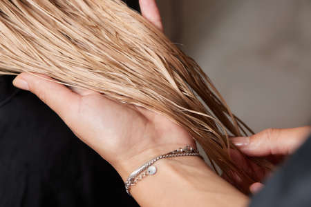 Airtouch Hair stylist makes bouffant using comb on thin strands. Shatush technique for hair lightening.の写真素材