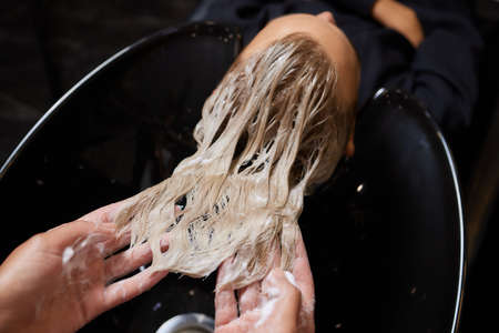 Hairstylist Hairdresser Washing Customer Hair - Young Man Relaxing In Hairdressing Beauty Salon.の写真素材