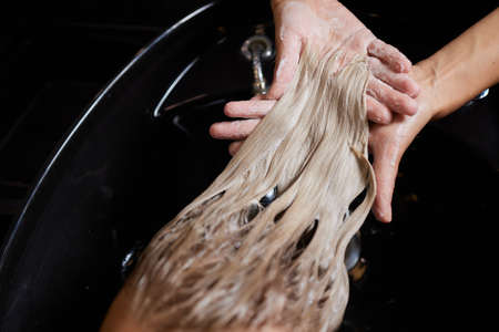 Hairstylist Hairdresser Washing Customer Hair - Young Man Relaxing In Hairdressing Beauty Salon.の写真素材
