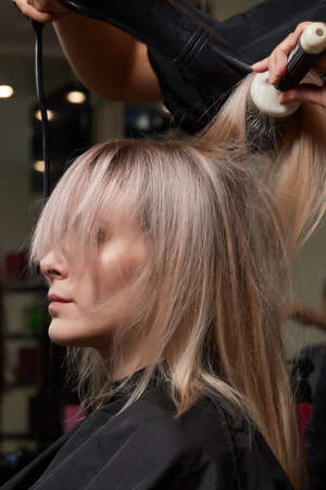 Beautiful hairstyle of young woman after dyeing hair and making highlights in hair salon.の写真素材