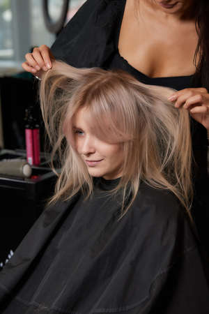 Beautiful hairstyle of young woman after dyeing hair and making highlights in hair salon.の写真素材