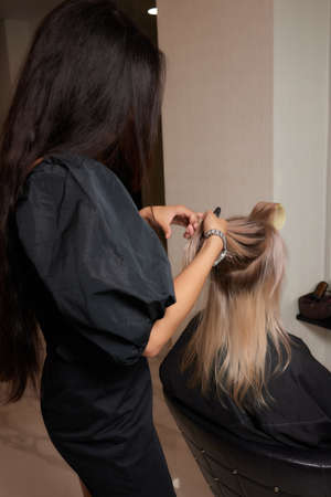 Beautiful hairstyle of young woman after dyeing hair and making highlights in hair salon.の写真素材