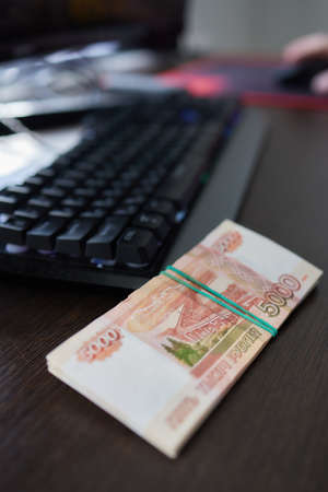 Russian money above the black computer keyboard. Remote job and freelance in Russia. Banknote of...