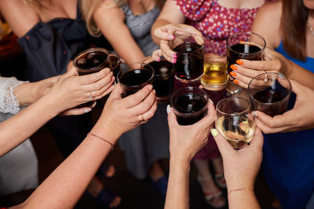 Celebrating with glasses of alcohol in hands. Happy female friends having good time.の写真素材