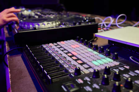 control DJ for mixing music with blurred people dancing at party in nightclub.の写真素材