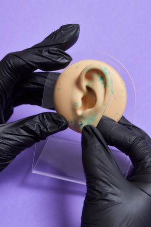 Professional placing the jewel of training silicone for ear piercing Tragus type.の写真素材